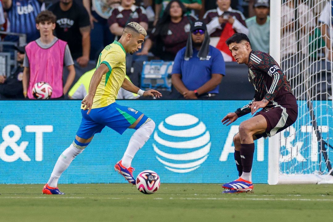 El defensa brasileño Yan Couto (i) intenta regatear al mexicano Edson Alvarez (d) durante un partido amistoso. EFE/Adam Davis