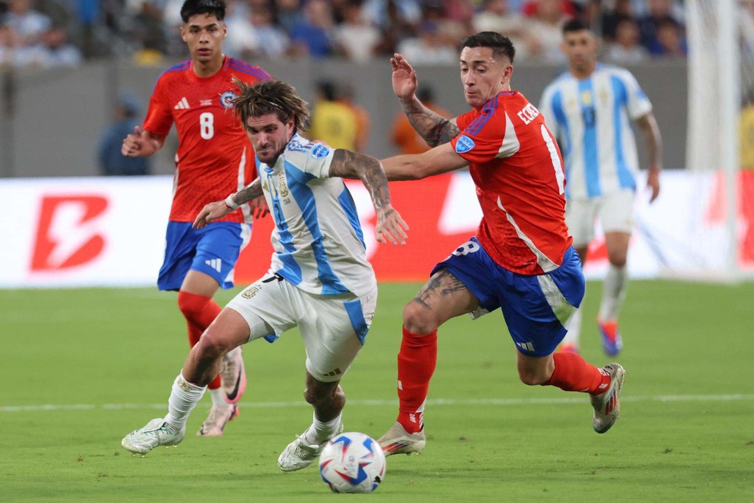 El centrocampista argentino Rodrigo de Paul (c-i) fue registrado este martes, 25 de junio, al disputar un balón el defensor chileno Rodrigo Echeverría (c-d), durante un partido de la fecha 2 del grupo A de la Copa América, en el estadio MetLife de East Rutherford (Nueva Jersey, EE.UU.). EFE/Justin Lane