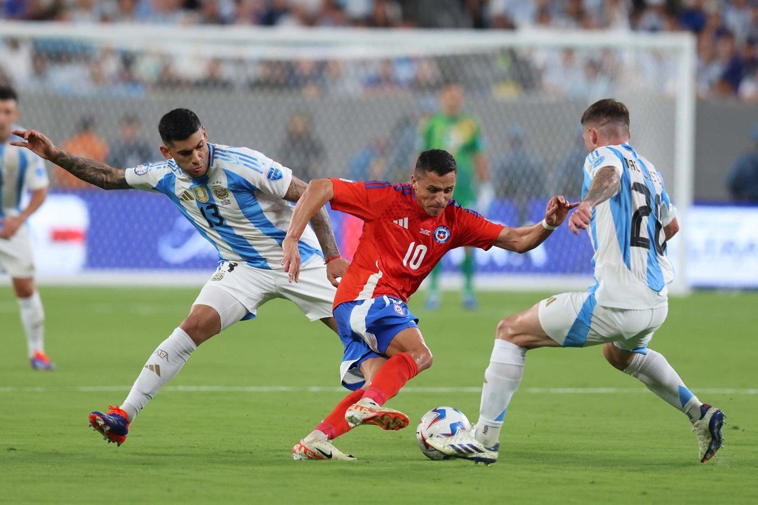 El defensor argentino Cristian Romero (i) y el centrocampista Alexis Mac Allister (d) desafían al delantero chileno Alexis Sánchez (C) durante la Copa América 2024. EFE/EPA/JUSTIN LANE