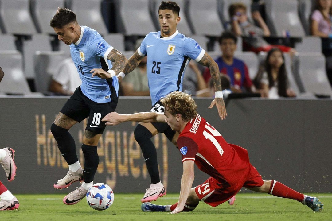 El delantero uruguayo Brian Rodríguez (i), fue registrado este sábado, 13 de julio, al intentar superar la marca del centrocampista canadiense Jacob Shaffelburg (d), durante el partido por el tercer puesto en la Copa América 2024, en el estadio Bank of America de Charlotte (Carolina del Norte, EE.UU.). EFE/Erik S. Lesser