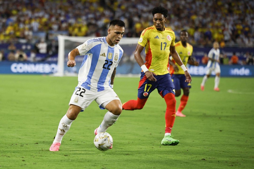 El delantero argentino Lautaro Martínez (i) fue registrado este domingo, 14 de julio, al intentar superar la marca del defensa colombiano Johan Mojica (c), durante la final de la Copa América 2024, en el estadio Hard Rock de Miami (Florida, EE.UU.). EFE/CJ Gunther