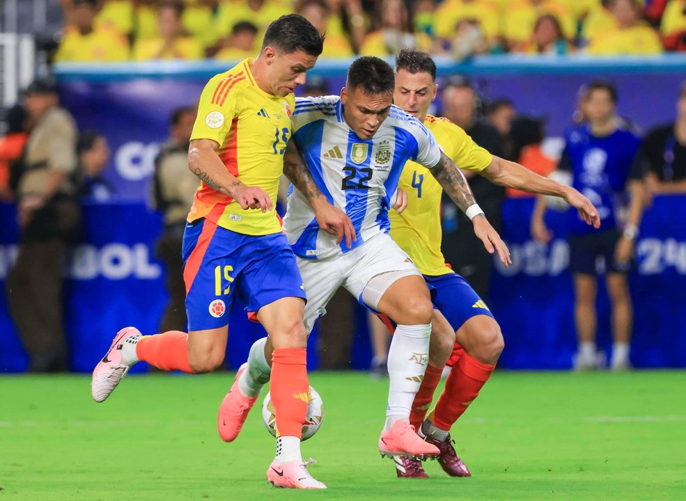 El delantero argentino Lautaro Martínez (c) fue registrado este domingo, 14 de julio, al disputar un balón con los jugadores colombianos Mateus Uribe (i) y Santiago Arias, durante la final de la Copa América 2024, en el estadio Hard Rock de Miami (Florida, EE.UU.). EFE/Cristóbal Herrera